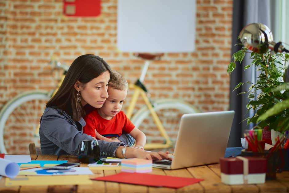 Mother clutches child as she works on a project