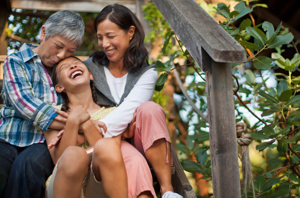 A diverse family hugs and laughs