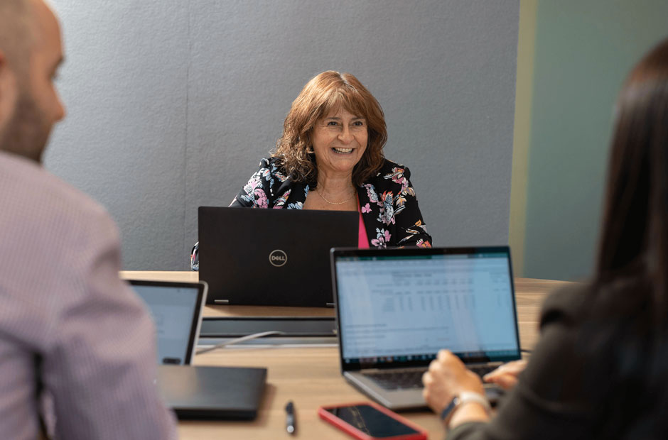 Underwriters gather around laptops to explore risk assessment insights