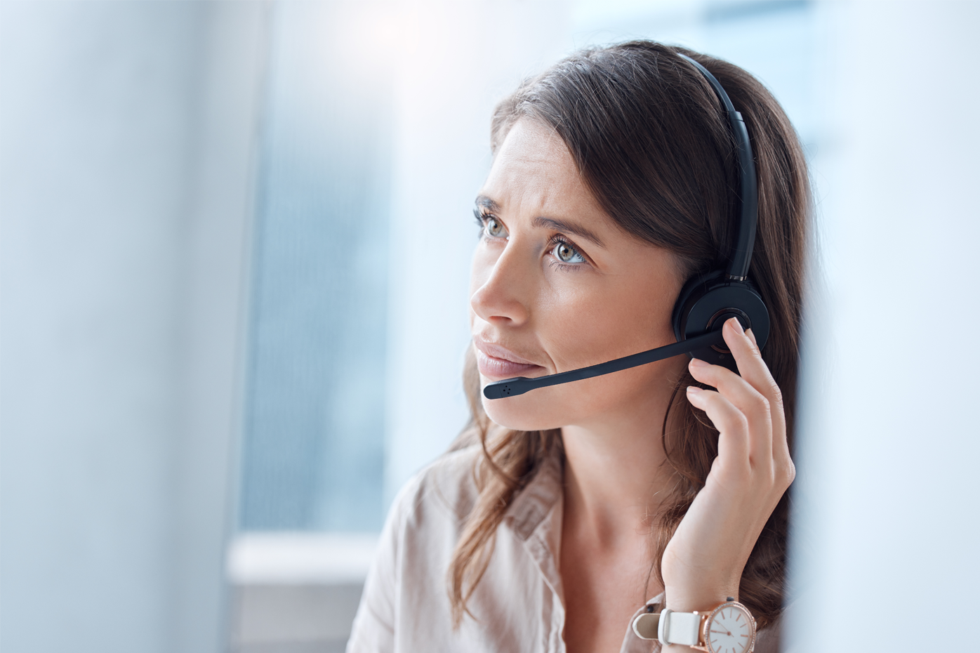 A woman wearing a headset listens with empathy to a customer's concerns