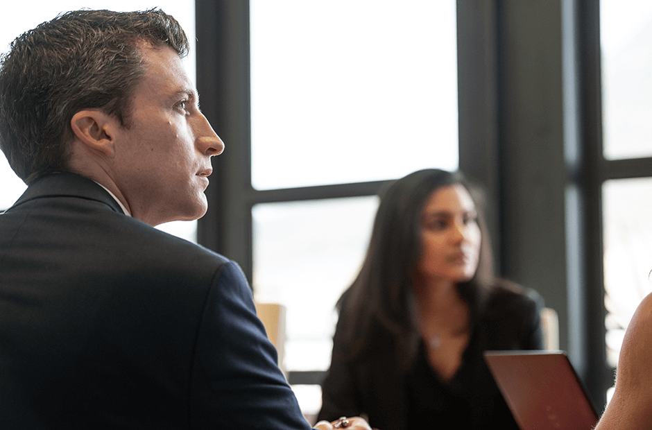 A group of employees in a meeting gaze ahead